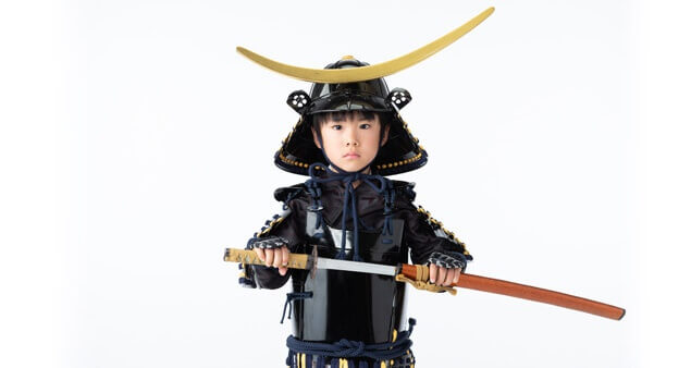 七五三5歳男の子の写真。衣装:鎧兜を着て、刀を抜いている様子