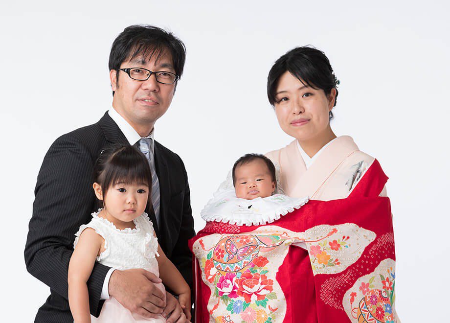 掛け衣裳を着た赤ちゃんと、家族4人のお宮参り記念写真
