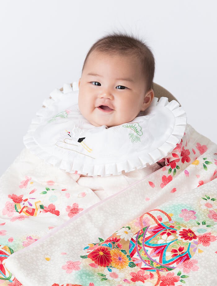 お宮参り祝いで、掛け衣裳を着た赤ちゃんの写真