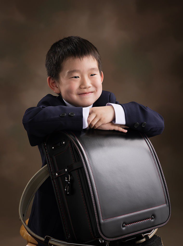 写真:ランドセルを抱えた小学校入学の男の子