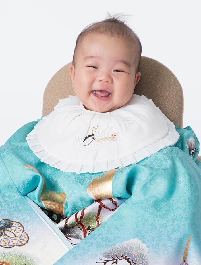 掛け衣裳を着た笑顔の赤ちゃん