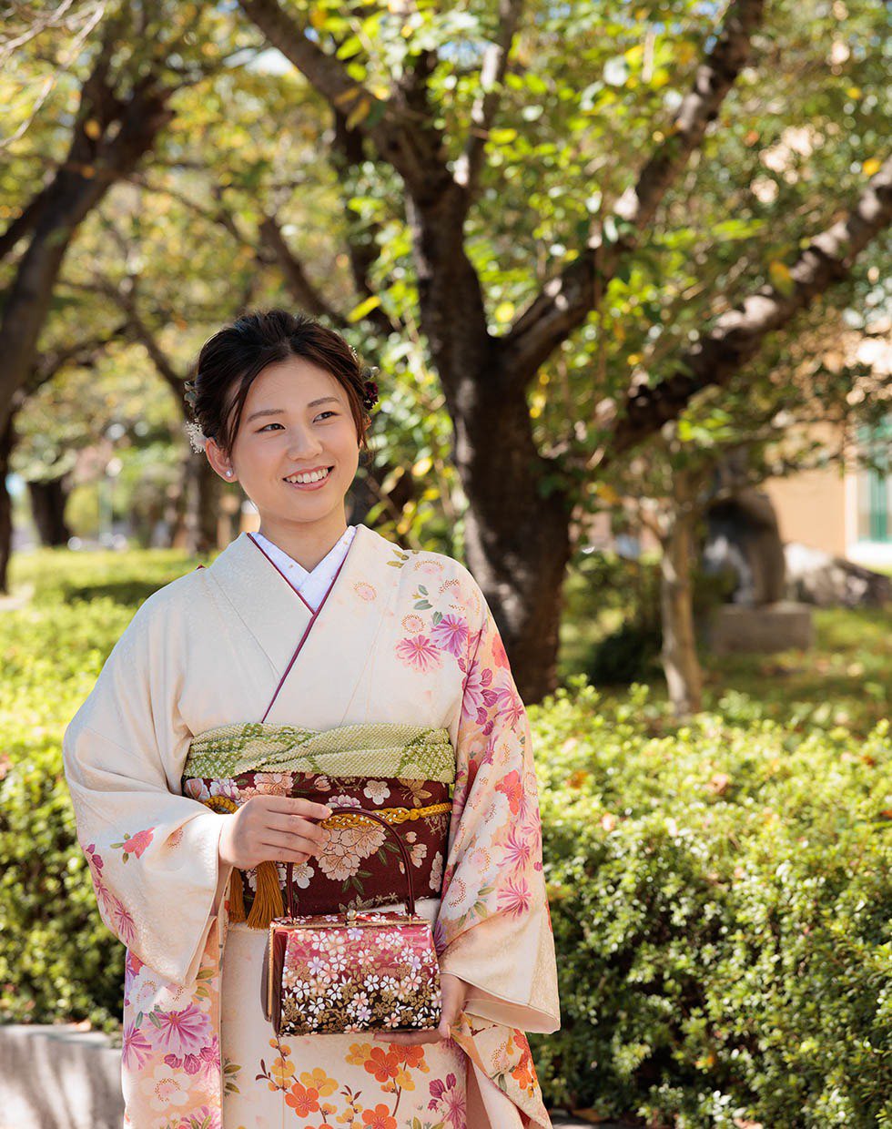 写真:振袖を着て自然光の中ロケ撮影をする女性