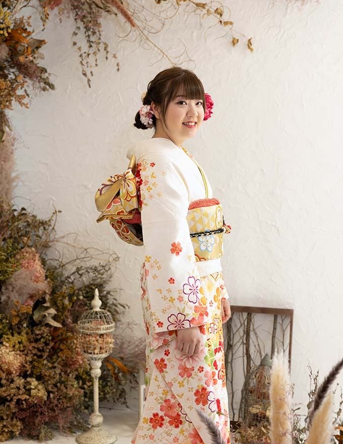 写真：振袖を着て成人式の記念撮影をする女性。